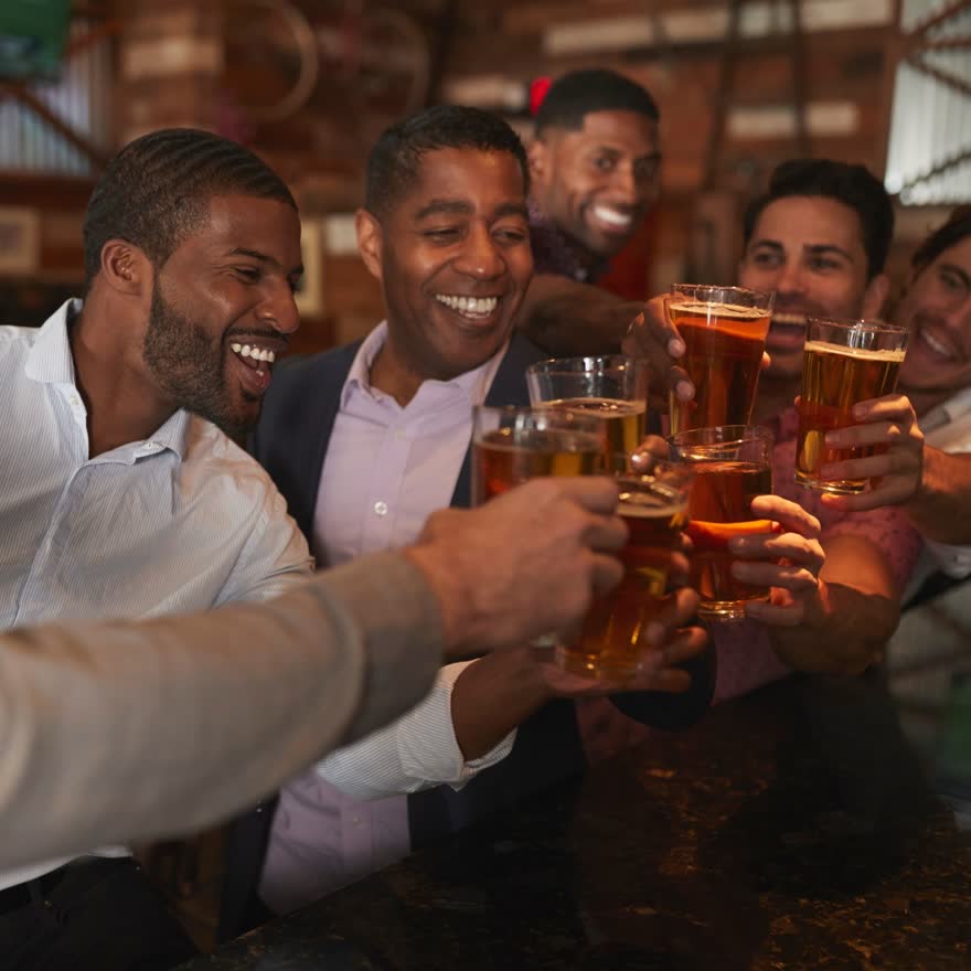 Amigos brindando con cervezas en una mesa antes de salir