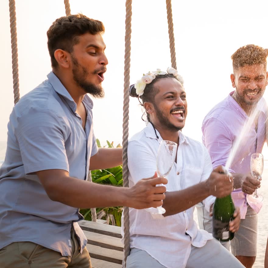Grupo celebrando al novio con bebidas durante una reunión previa