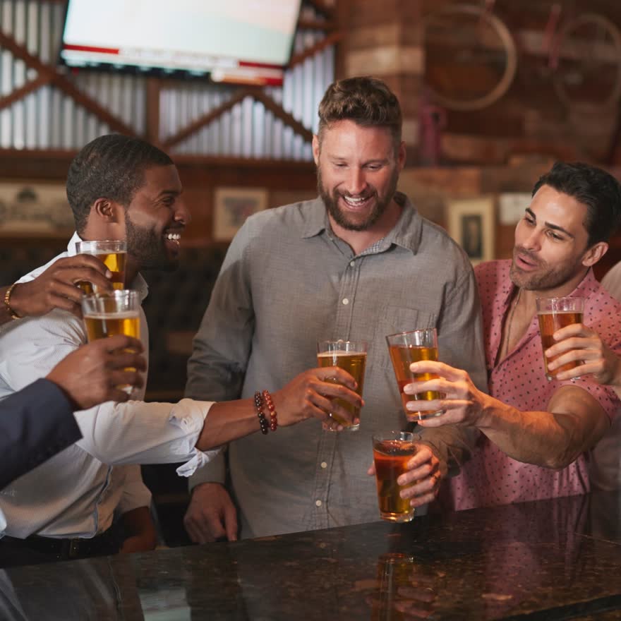 Grupo de amigos brindando con cerveza en una mesa