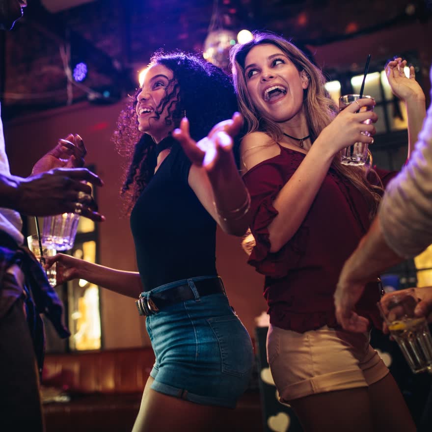 Personas cantando y bailando en una noche de antro