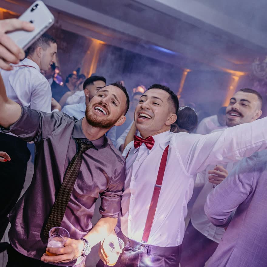Grupo de amigos tomándose una selfie en el antro durante la despedida